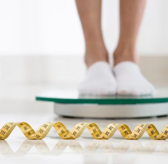 Pés sobre uma balança com fita métrica